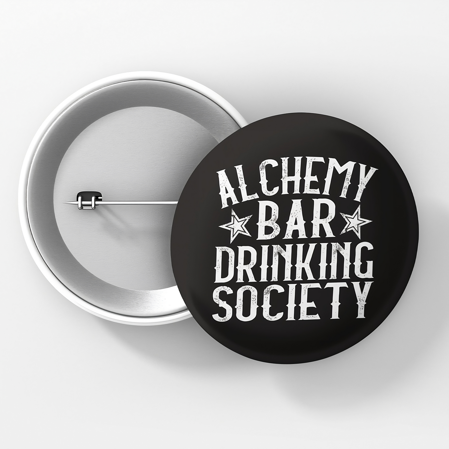 A round pinback button with a black background and white text that reads 'ALCHEMY BAR DRINKING SOCIETY' surrounded by three stars.