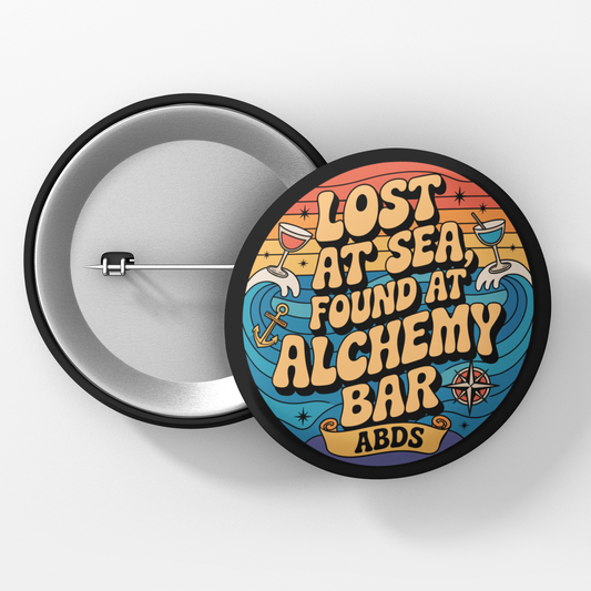 Button badge with 'Lost at Sea, Found at Alchemy Bar' text on a white background